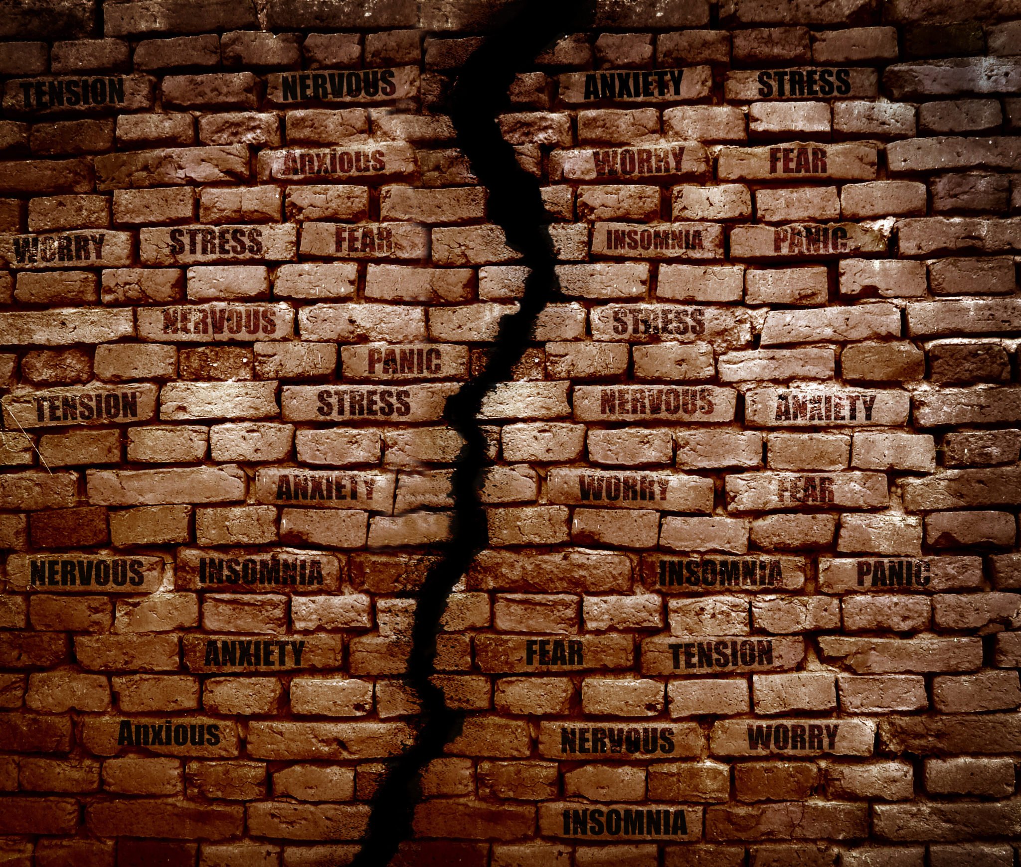 Crack in a brick wall with Stress, anxiety and various related messages
